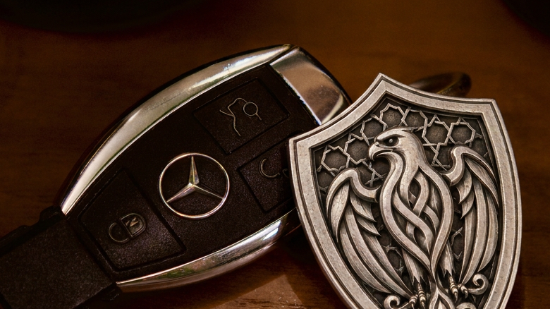 Arabian Falcon Shield Silver Keychain, front view beside a car key