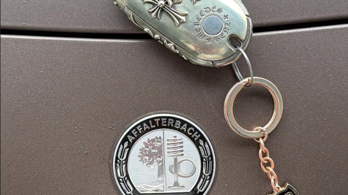 Customer photo showing an IGNIS ARGENTUM key case as a conversation starter on a luxury car interior