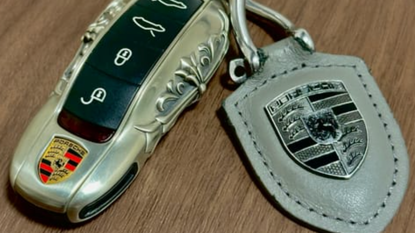 Customer photo showing an IGNIS ARGENTUM Porsche key case with leather tag and substantial smart key weight