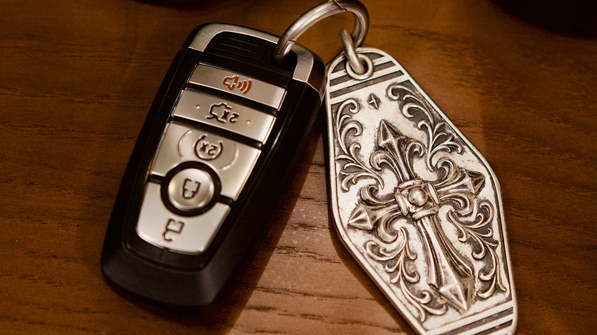 Personalized Cathedral Cross Silver Keychain, front view beside a car key