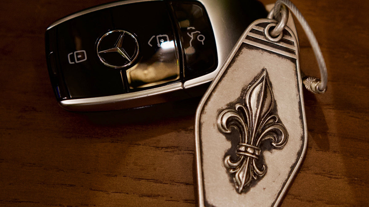 Royal Fleur Personalized Silver Keychain, front view beside a car key