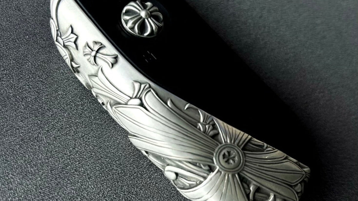 BMW Faceted Blade silver key case displayed in a dark lifestyle flat lay