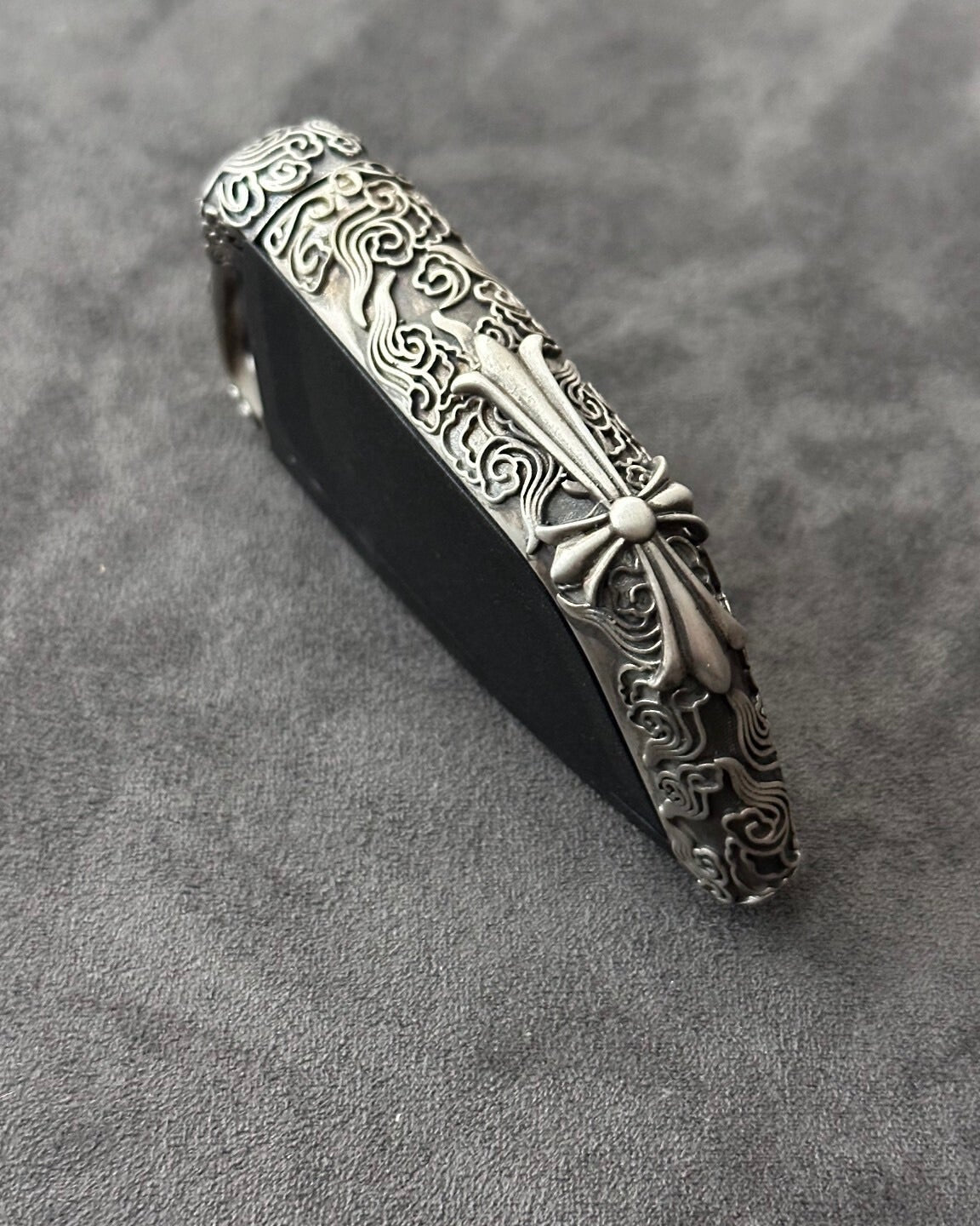 Side view showing the slim edge profile of the BMW cloud style sterling silver case, contrasting the raised engraved pattern against the matte background
