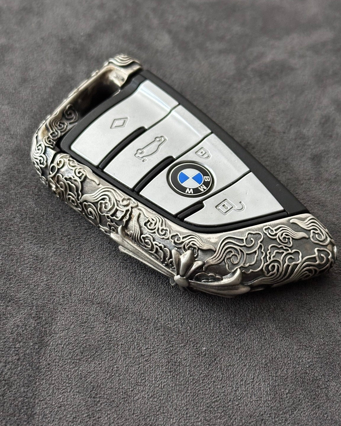 Side view showing the slim edge profile of the BMW cloud style sterling silver case, contrasting the raised engraved pattern against the matte background