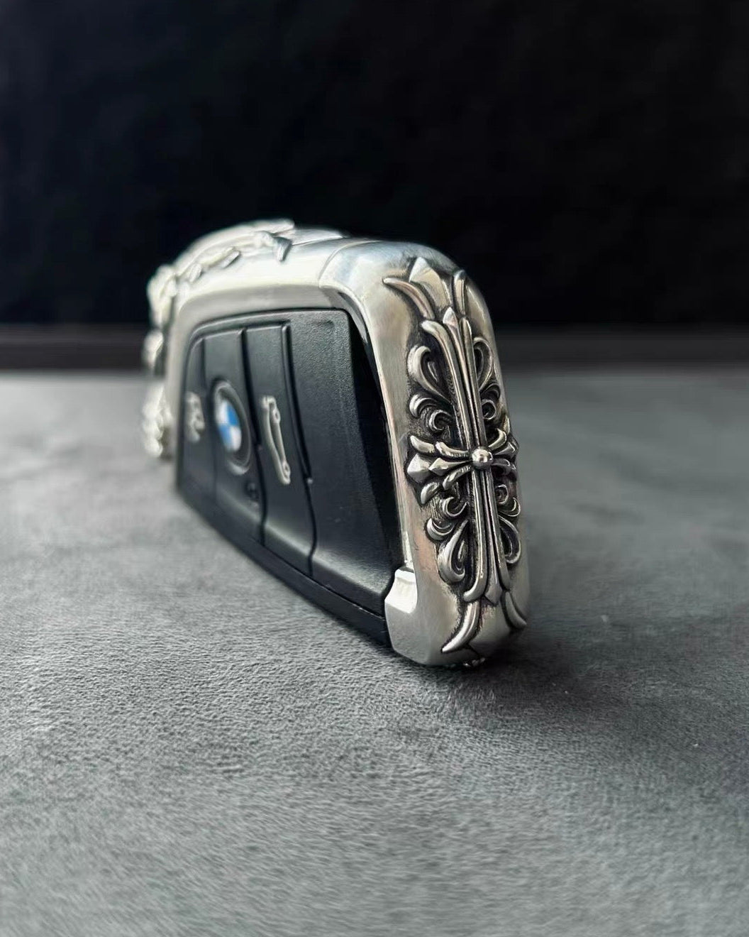 BMW slim edge key case angled side view on gray background showcasing slim profile uniform engraving extension and substantial hand-feel from multiple perspectives