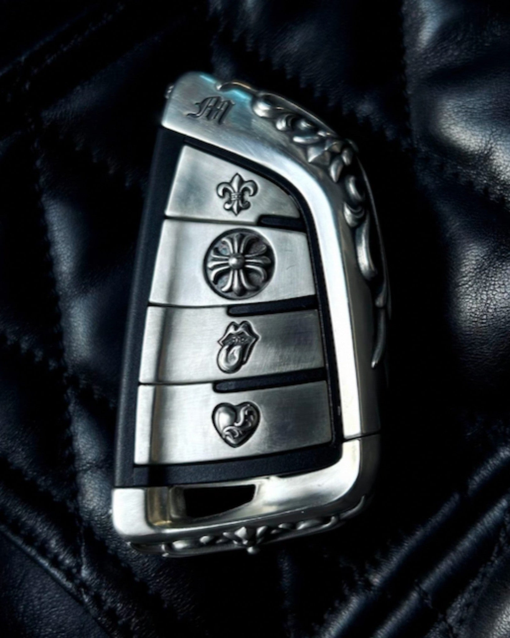 Hand-finished BMW slim edge key case front view on black leather background showing seamless fit and precise button alignment