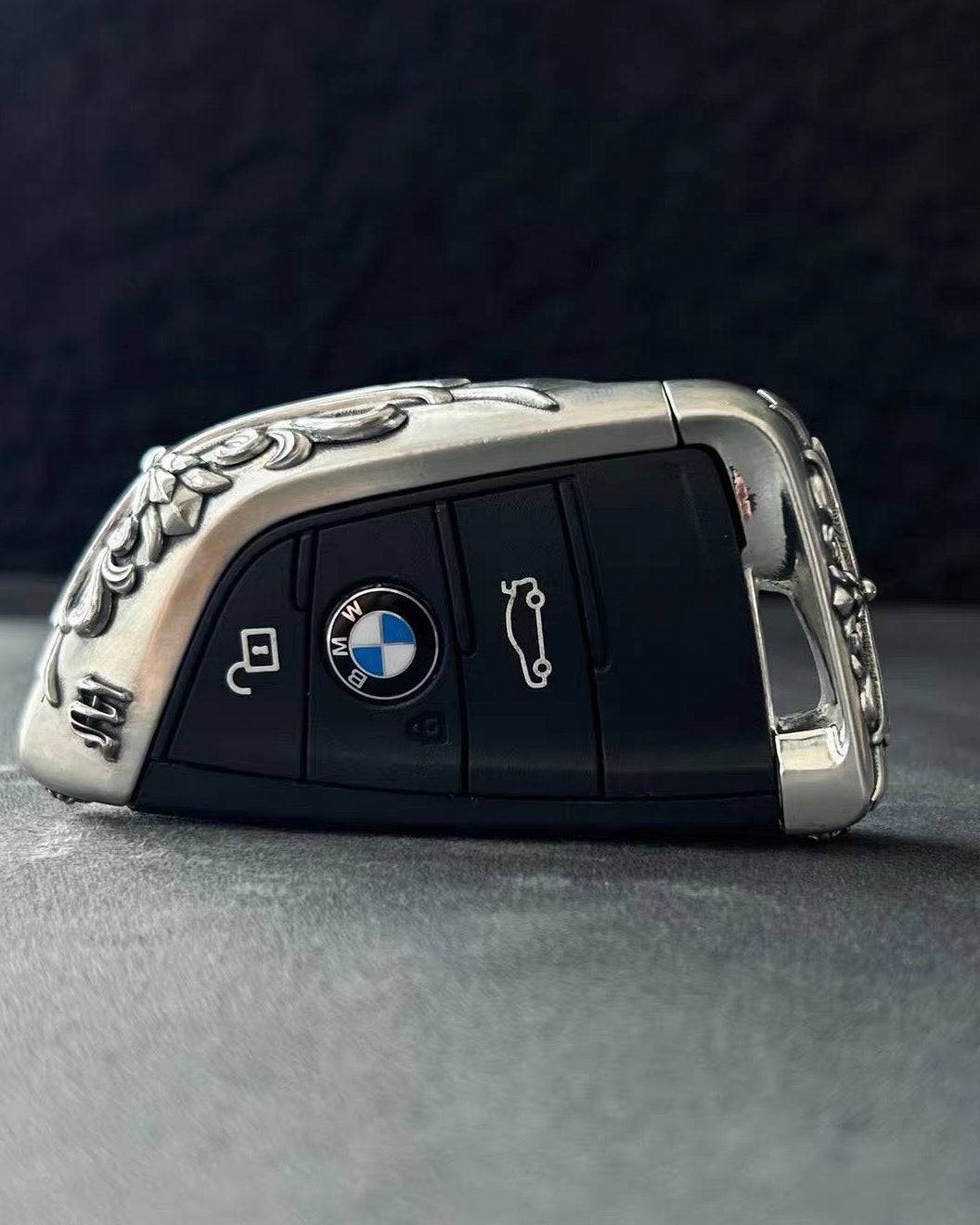 BMW slim edge key case overhead view on gray background showcasing symmetrical shape uniform engraving and intentional weight from top perspective
