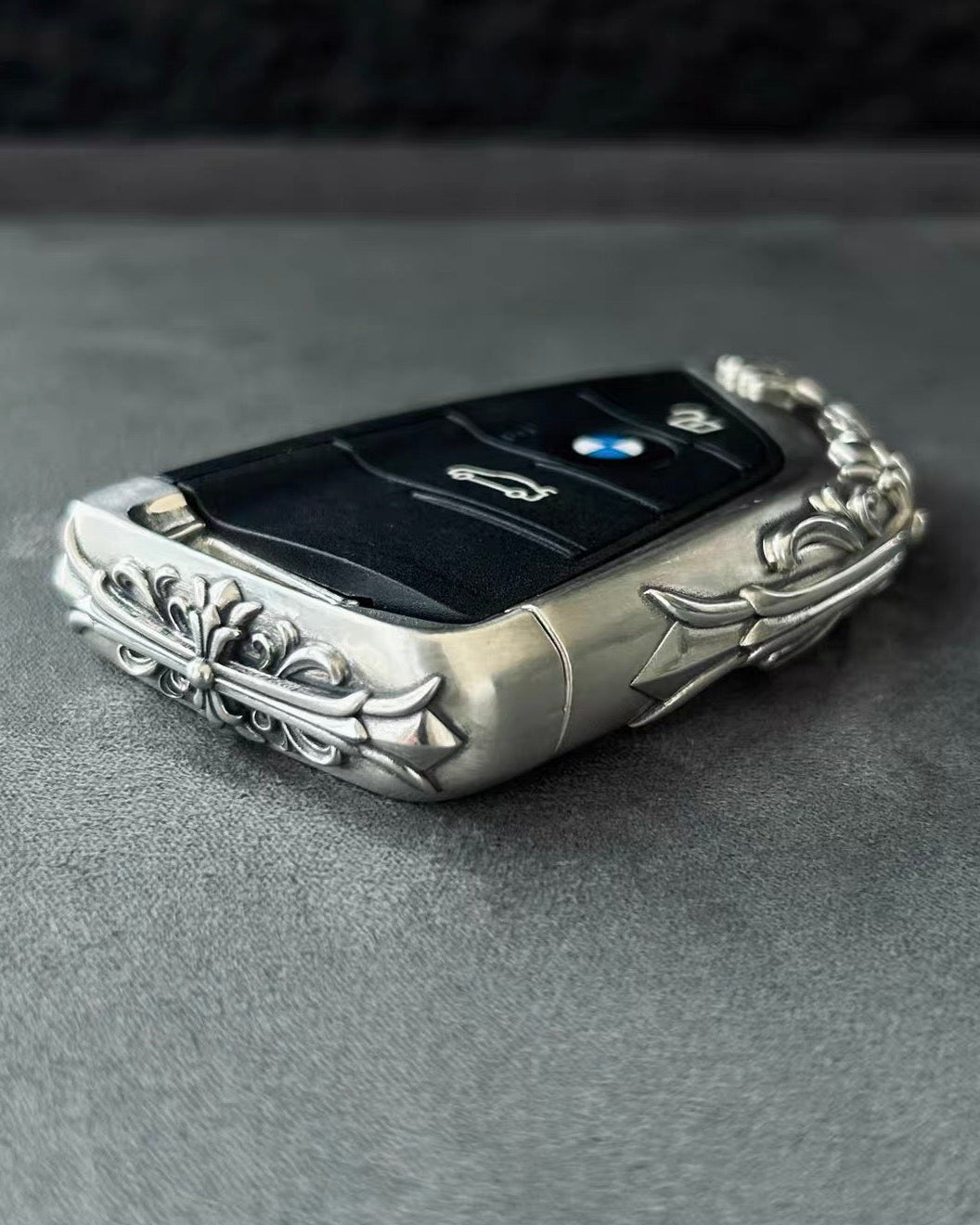 BMW slim edge key case side profile on gray background highlighting thickness engraved patterns and metal edge finishing without key inserted