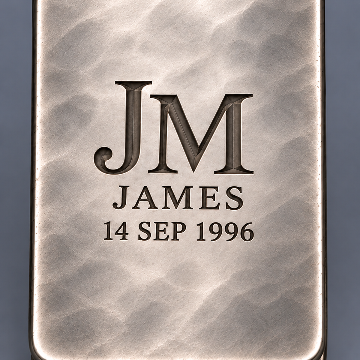 Macro detail of deep faceted monogram engraving on hand-planished silver