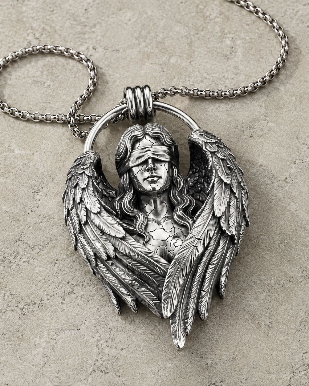 Fallen Angel Blindfolded Pendant, displayed on a dark surface