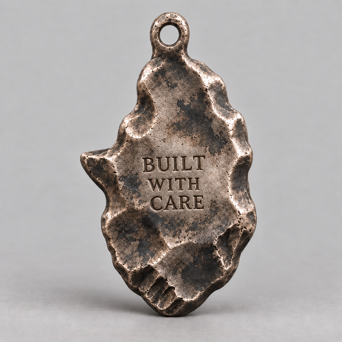 Hephaestus charm, personalized back engraving example: BUILT WITH CARE