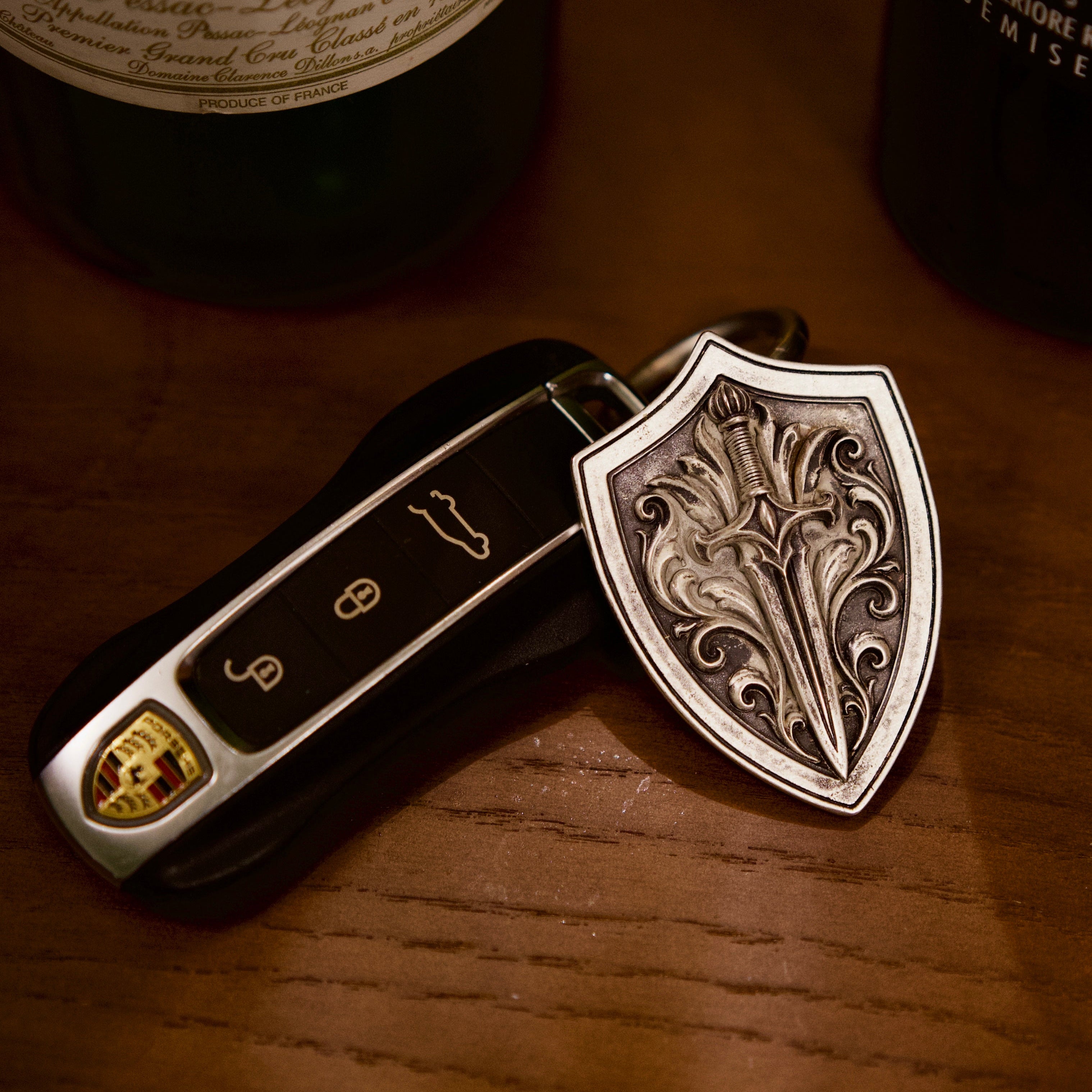 Aegis Blade Shield Silver Keychain, front view beside a car key