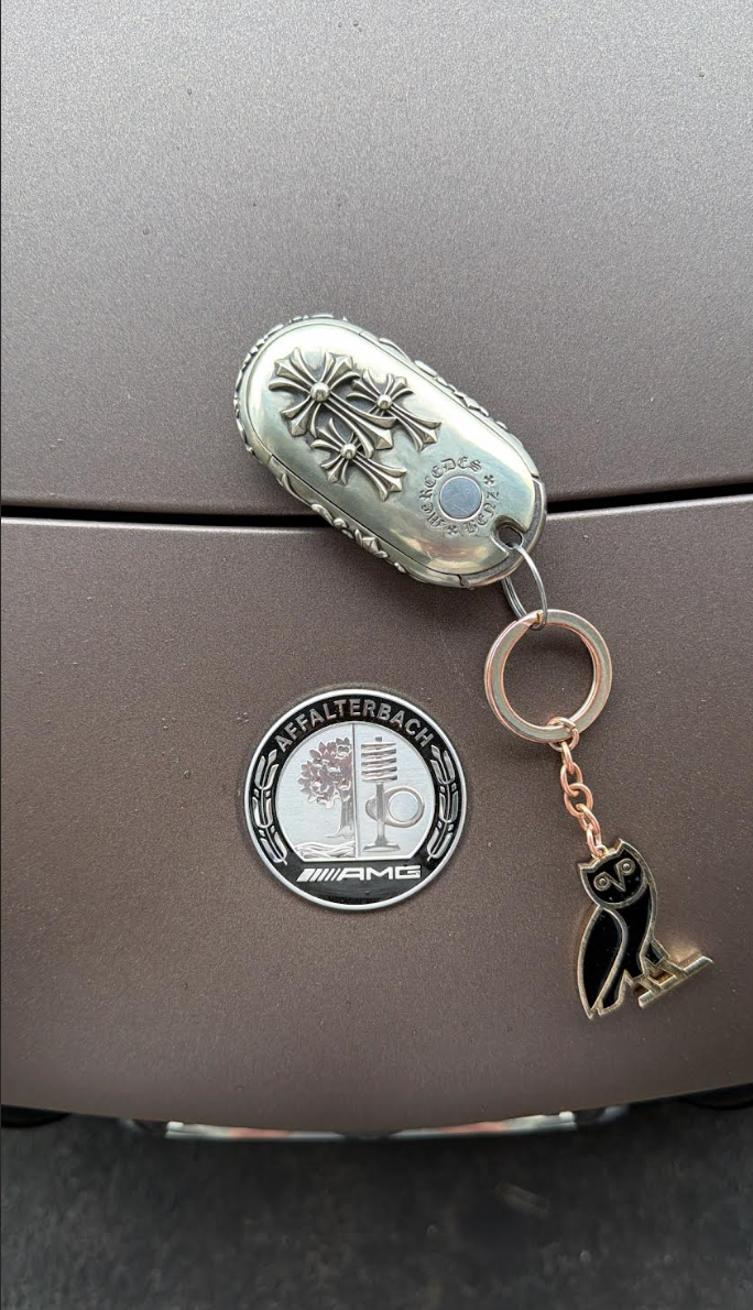 Customer photo showing an IGNIS ARGENTUM key case as a conversation starter on a luxury car interior