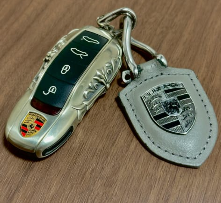 Customer photo showing an IGNIS ARGENTUM Porsche key case with leather tag and substantial smart key weight