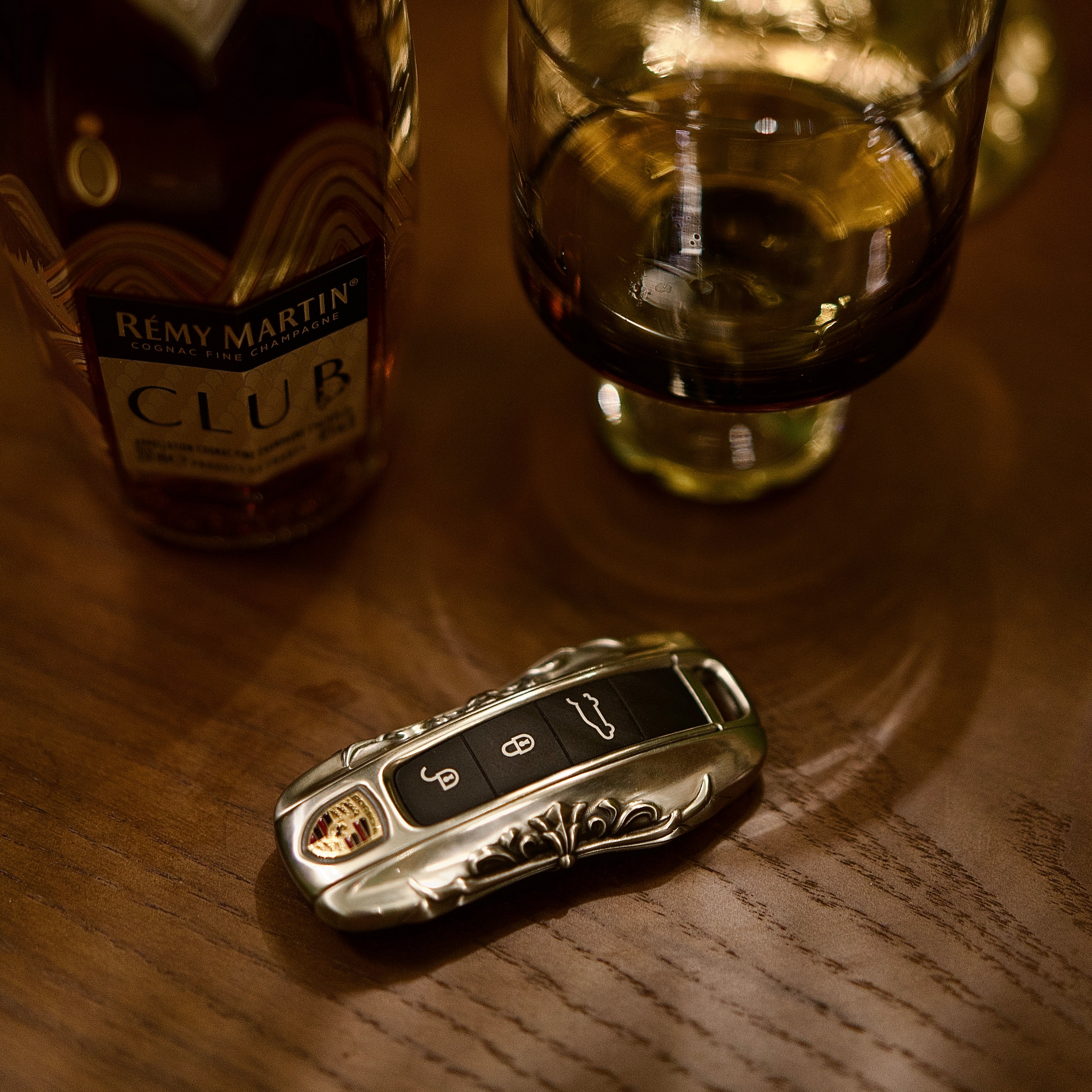 Handcrafted Porsche silver key case presented on a wooden desktop as a gift