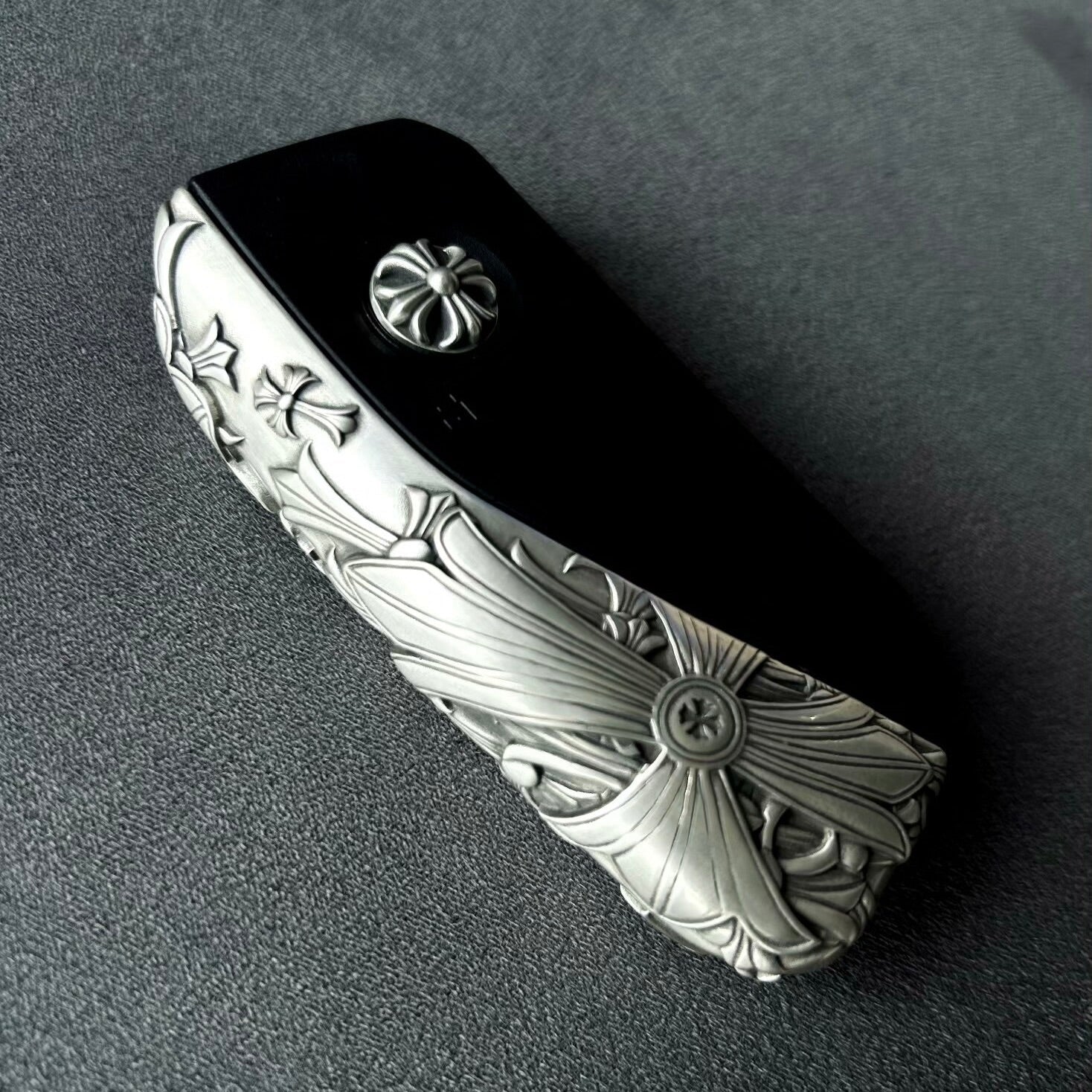 BMW Faceted Blade silver key case displayed in a dark lifestyle flat lay