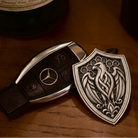 Arabian Falcon Shield Silver Keychain, front view beside a car key