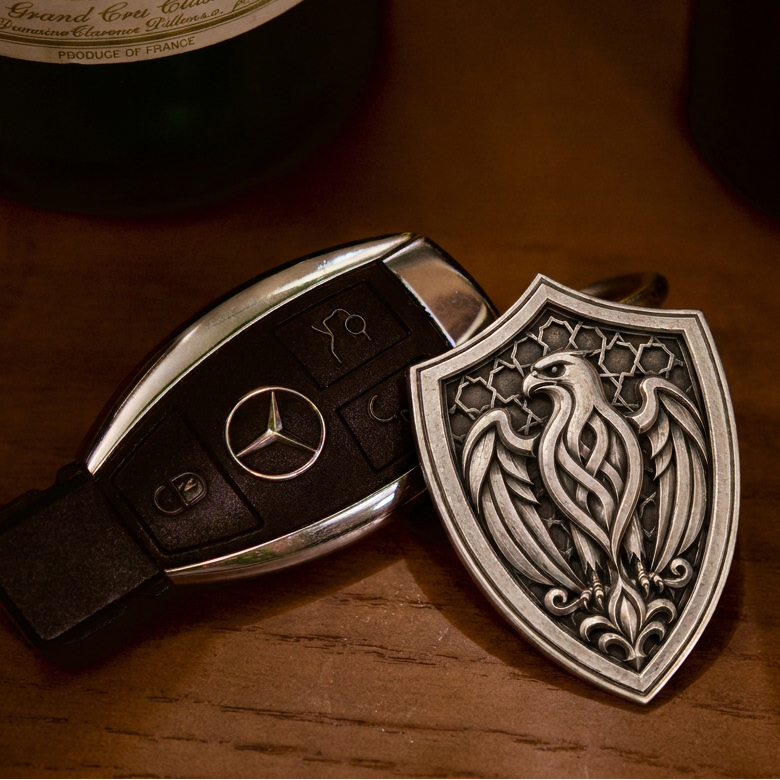 Arabian Falcon Shield Silver Keychain, front view beside a car key