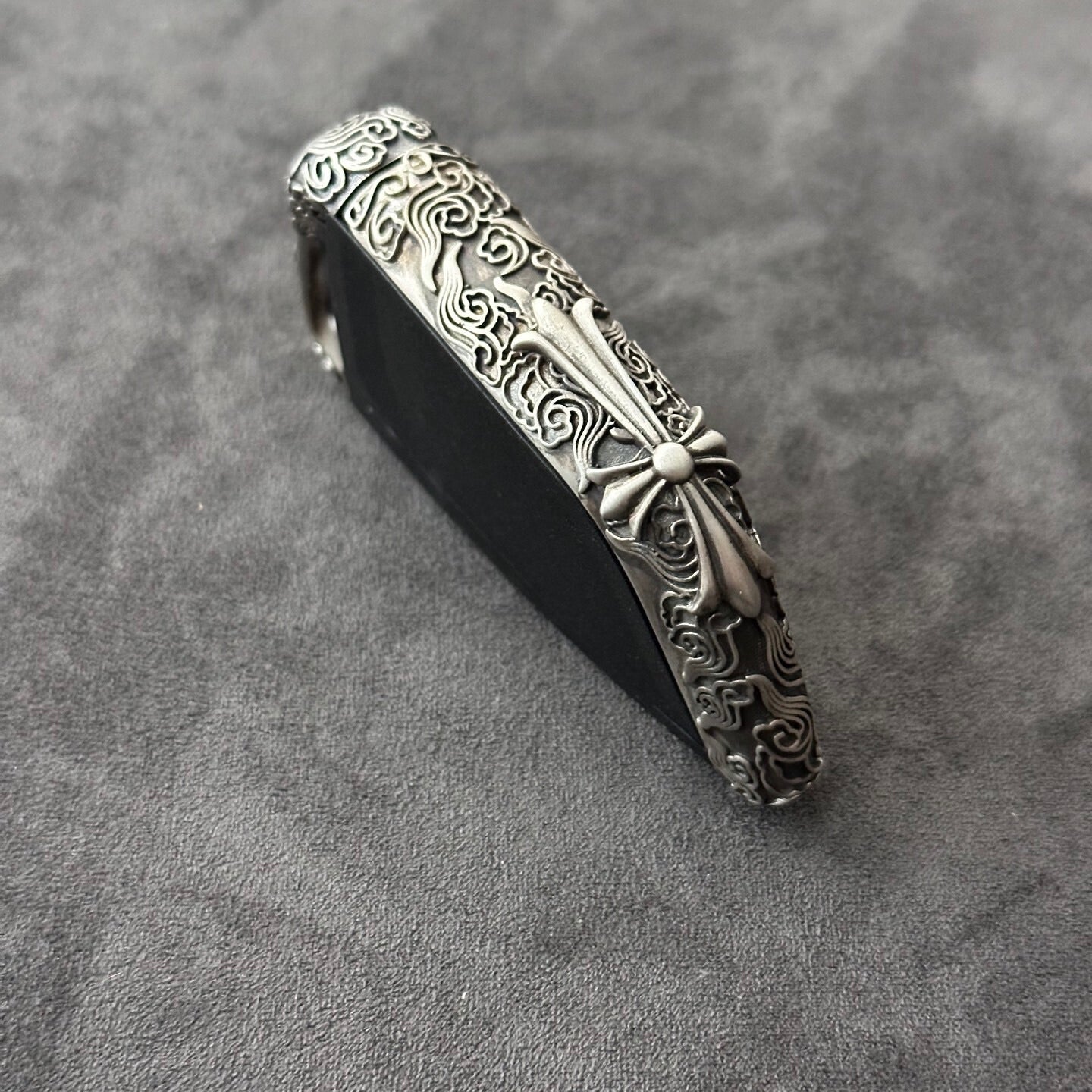Side view showing the slim edge profile of the BMW cloud style sterling silver case, contrasting the raised engraved pattern against the matte background