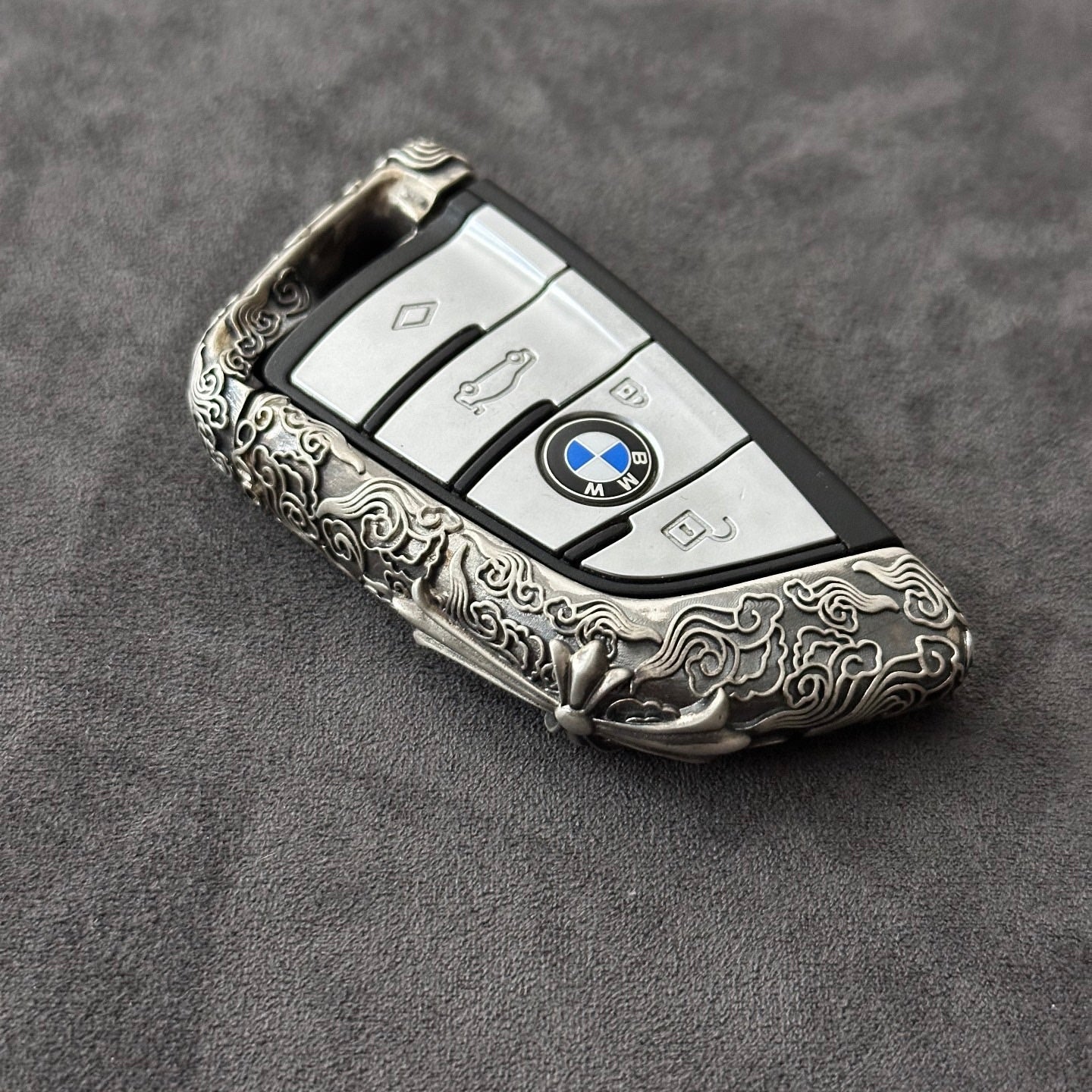 Side view showing the slim edge profile of the BMW cloud style sterling silver case, contrasting the raised engraved pattern against the matte background