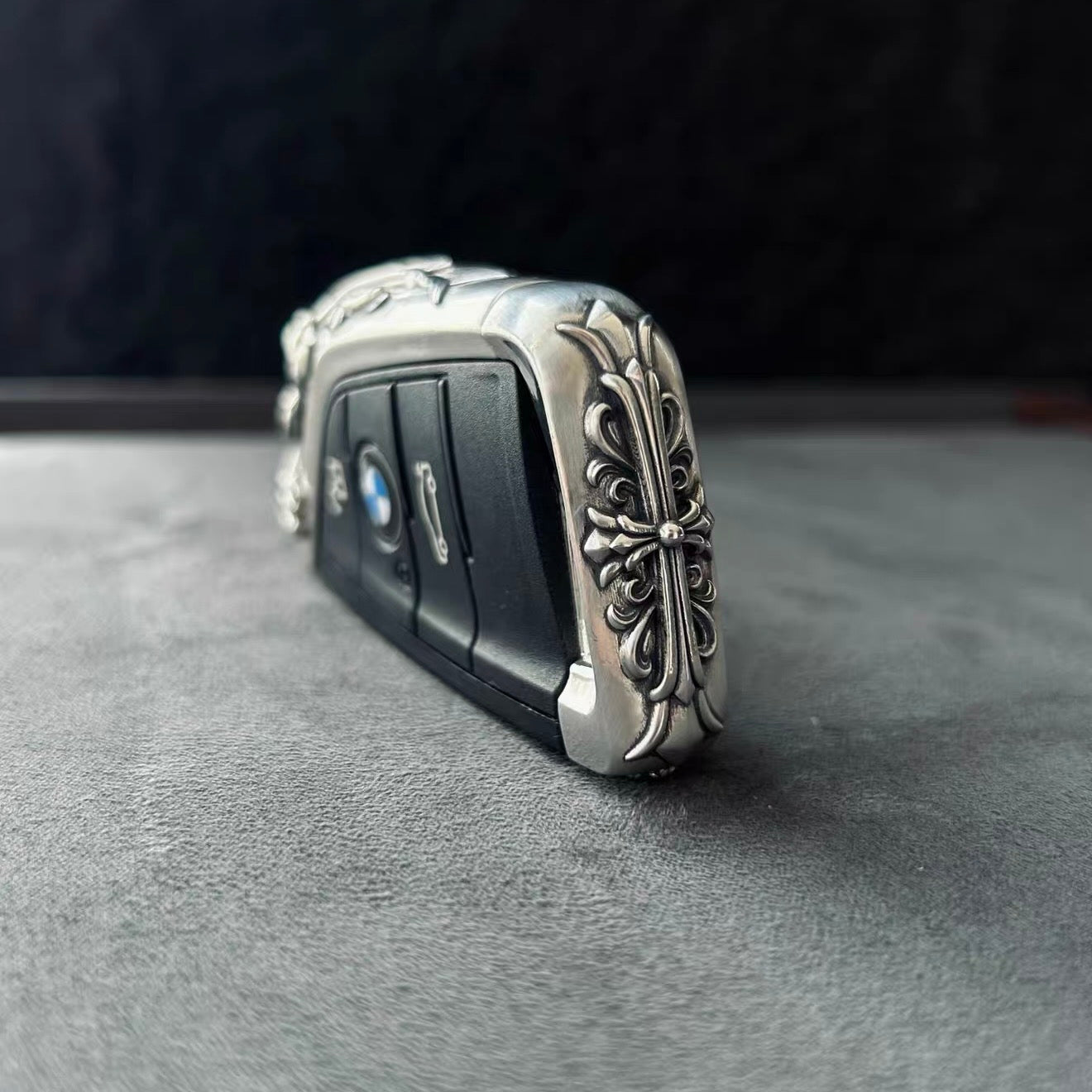 BMW slim edge key case angled side view on gray background showcasing slim profile uniform engraving extension and substantial hand-feel from multiple perspectives