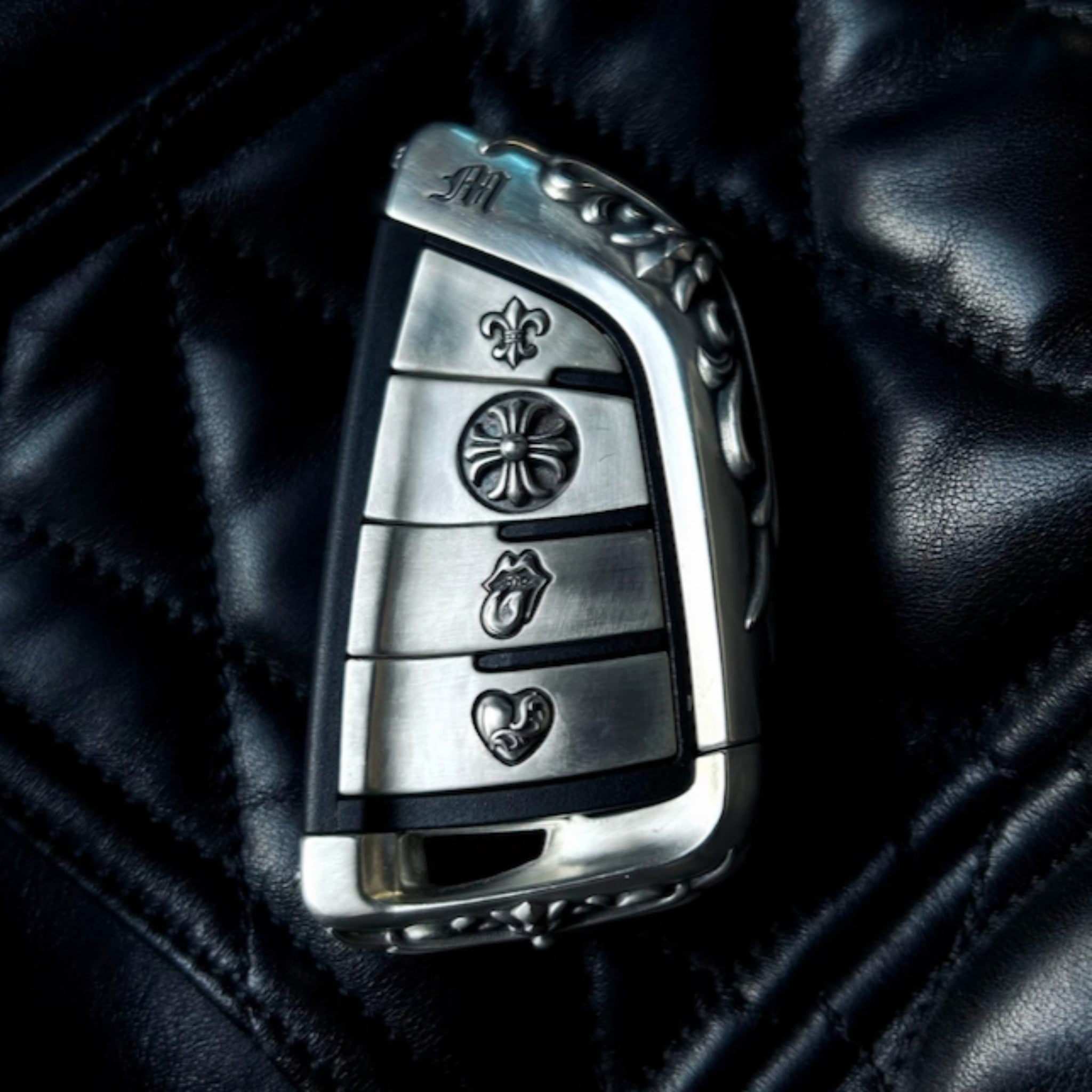 Hand-finished BMW slim edge key case front view on black leather background showing seamless fit and precise button alignment