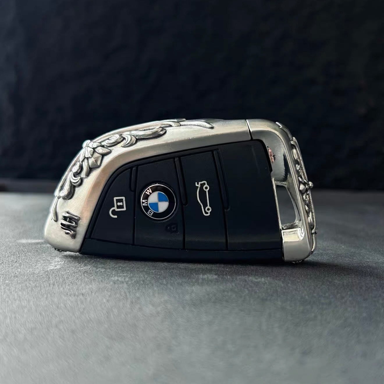 BMW slim edge key case overhead view on gray background showcasing symmetrical shape uniform engraving and intentional weight from top perspective