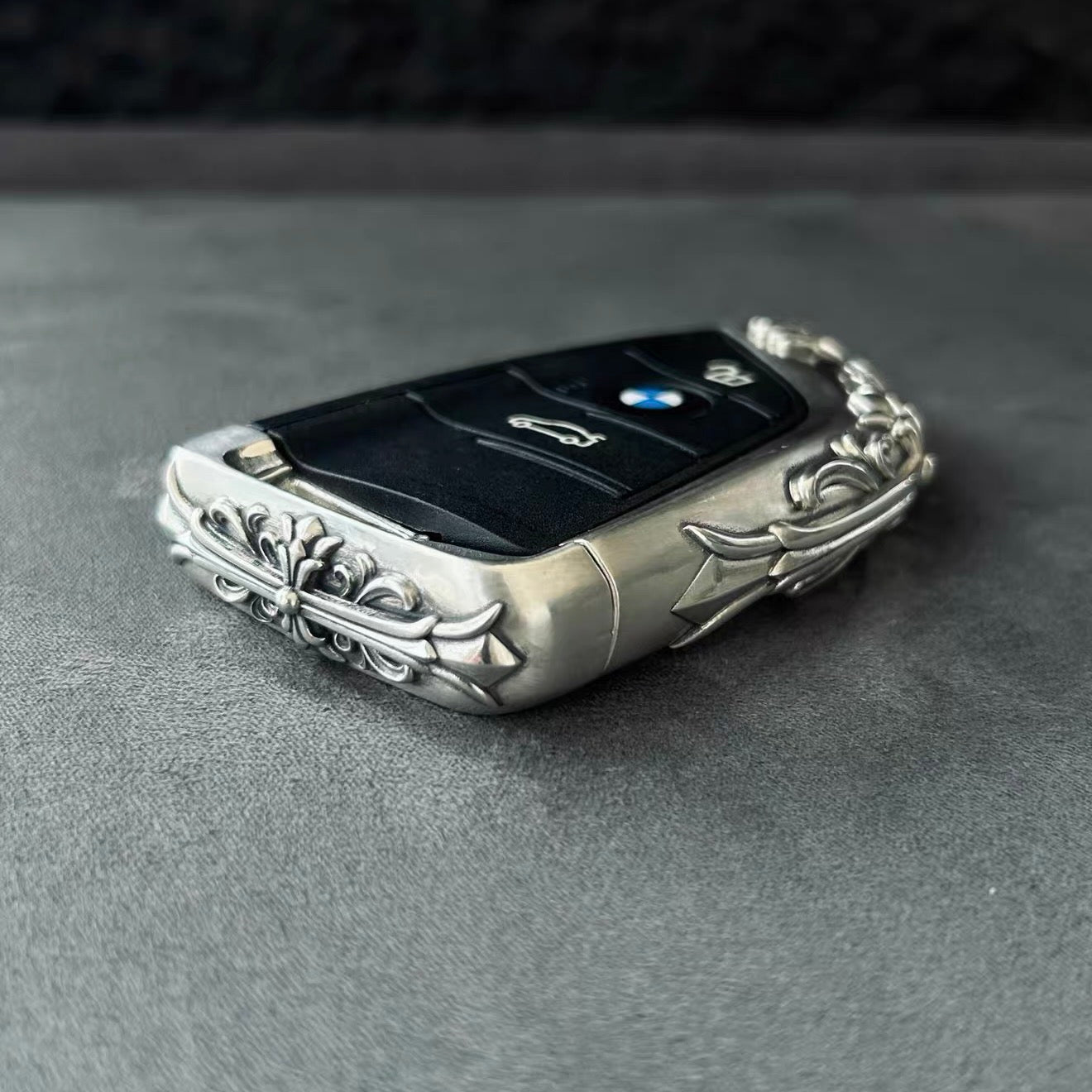 BMW slim edge key case side profile on gray background highlighting thickness engraved patterns and metal edge finishing without key inserted