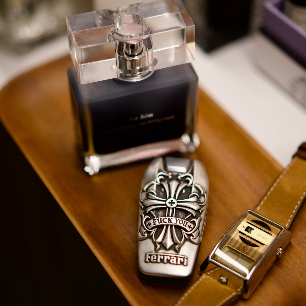 Custom Ferrari Key Case, displayed beside fragrance bottle and watch
