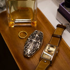 Custom McLaren Key Case, displayed beside fragrance bottle and watch