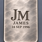 Macro detail of deep faceted monogram engraving on hand-planished silver
