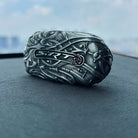 Sterling silver Dodge key case displayed on car dashboard, showcasing complete dragon head sculpture and hand-carved ornamental patterns with substantial presence