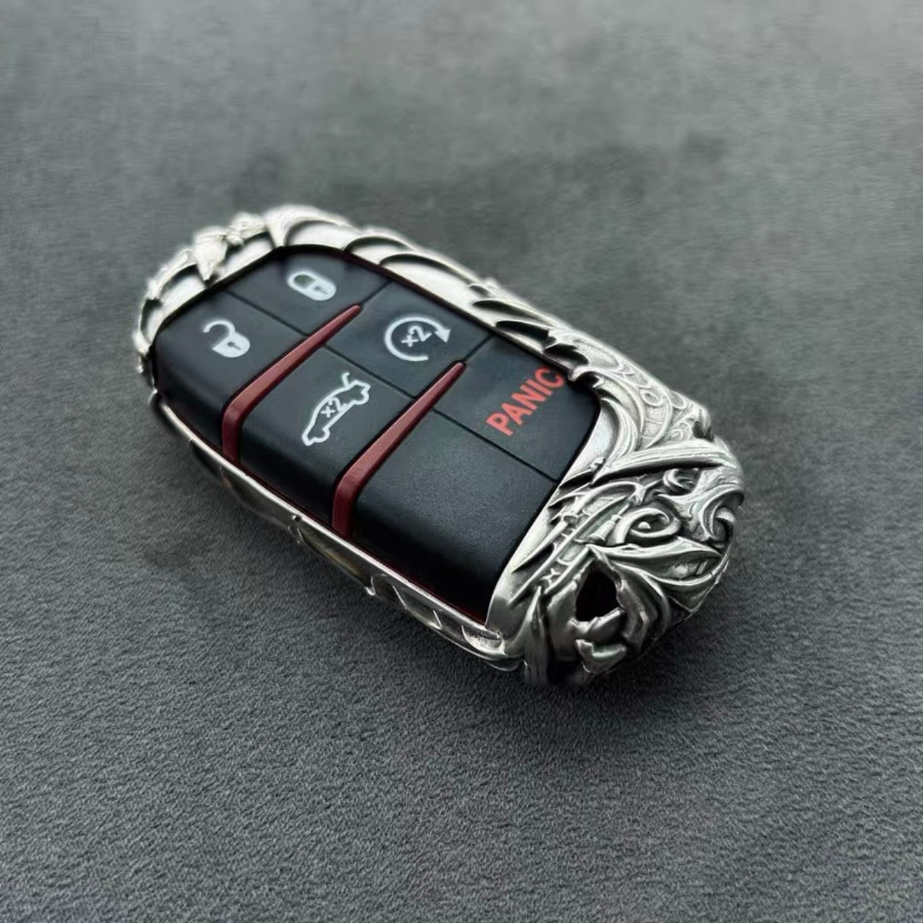 Dodge handcrafted sterling silver key case front view featuring intricate dragon motif carving, three-button layout with red panic button, and solid 925 silver frame with refined detailing