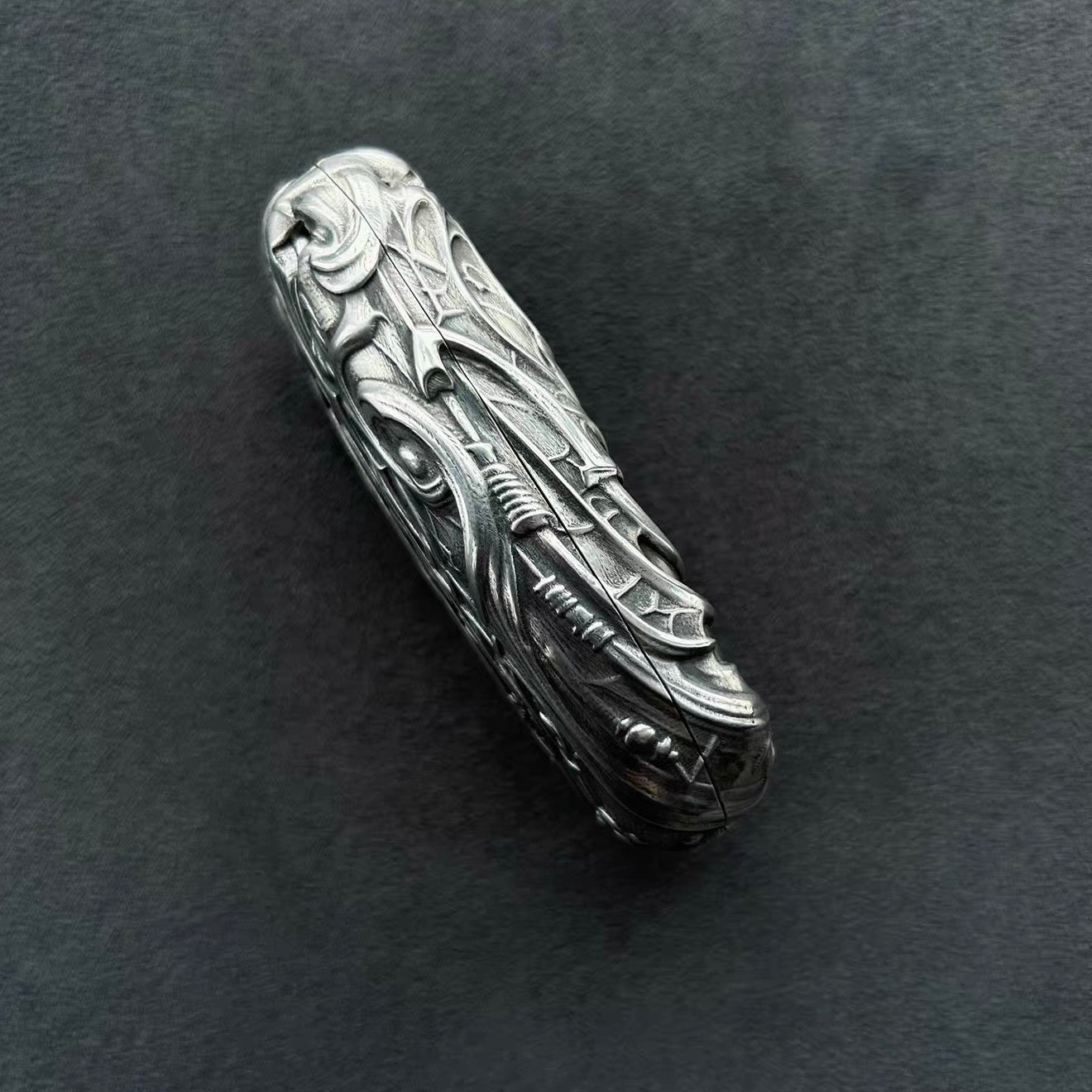 Side profile of Dodge handcrafted sterling silver key case highlighting three-dimensional dragon body engraving, sculpted edges and intentional weight (90g) with heirloom quality