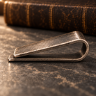 Side profile showing the spring shape and shorter front plate of the money clip