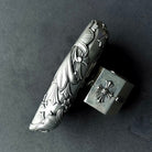 Close-up of intricate faceted blade engraving on handcrafted solid silver surface