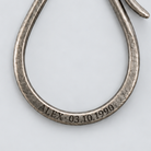 Illustrative personal engraving on the Patina Key Hook lower loop; a close-up of ALEX and a birthday, with no text overlay