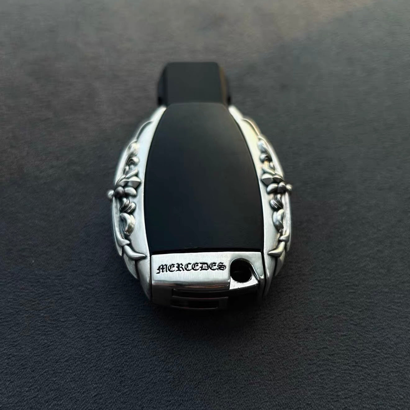 Hand-finished back engraving detail on IGNIS ARGENTUM Mercedes classic oval key case showing refined craftsmanship and polished metal texture
