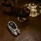 Substantial silver key case for Mercedes owner lifestyle presentation on wooden table showcasing understated luxury and refined weight