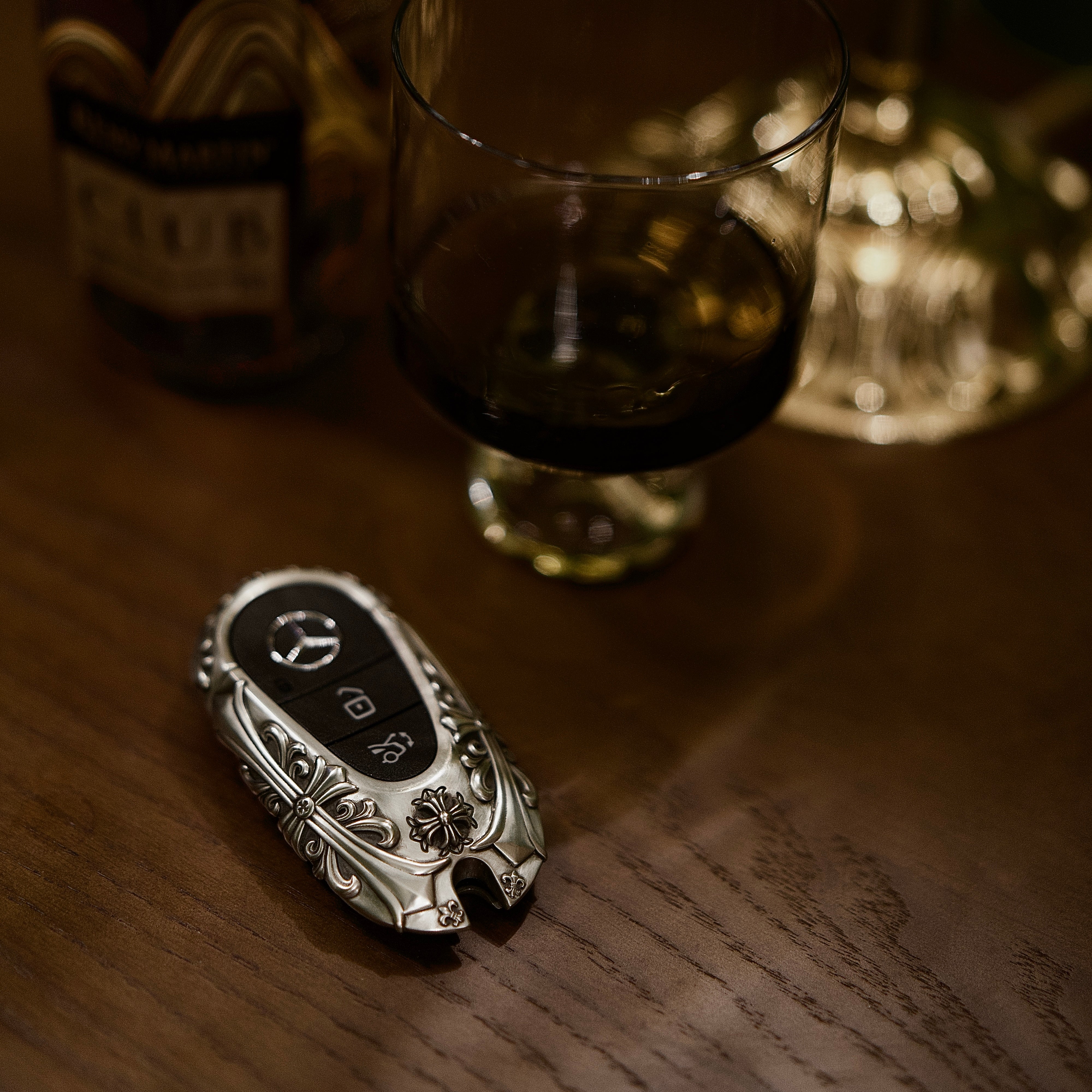 Substantial silver key case for Mercedes owner lifestyle presentation on wooden table showcasing understated luxury and refined weight