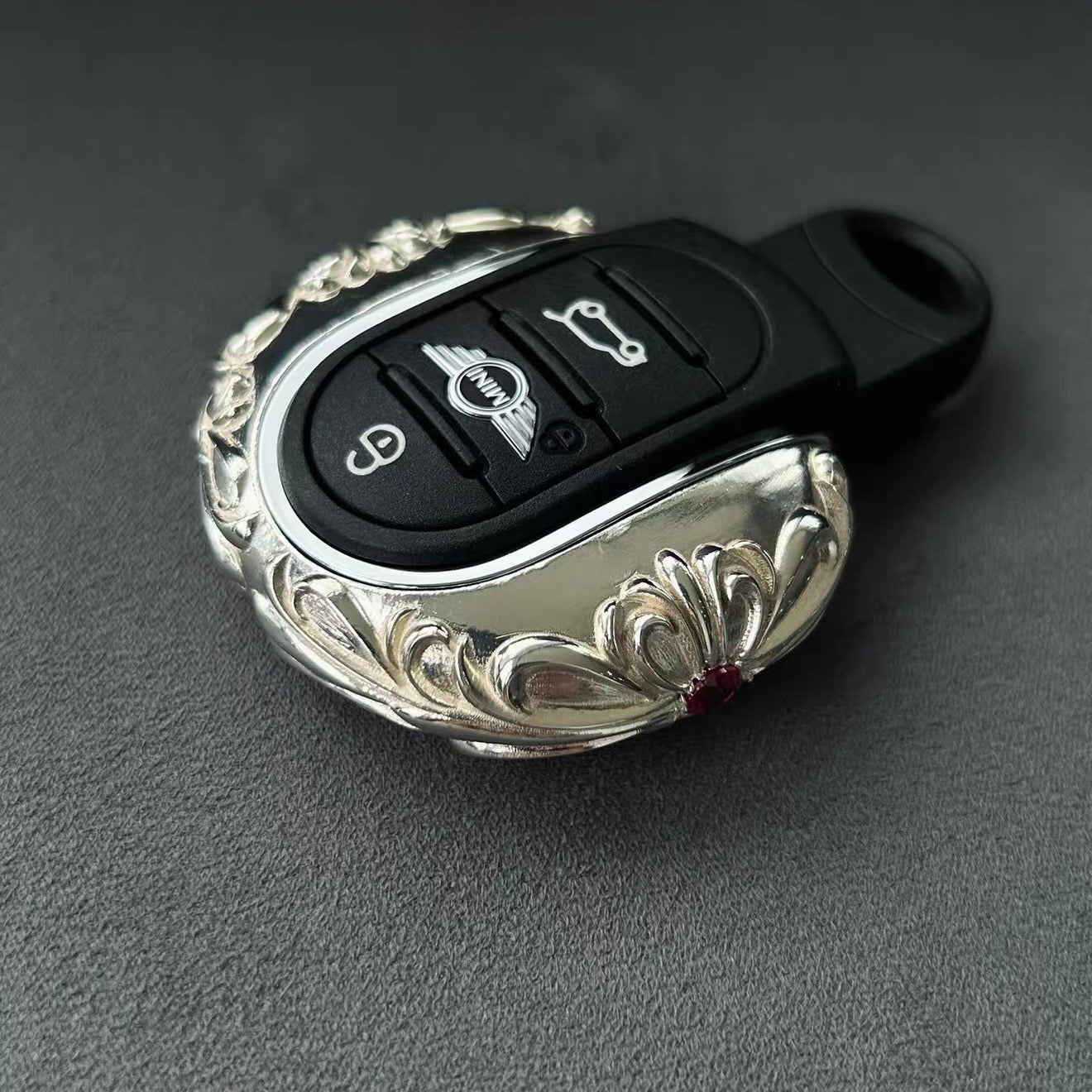 Red Gemstone Accent Detail on Handcrafted Silver MINI Key Cover - Refined Patina Understated Luxury Craftsmanship Close-Up