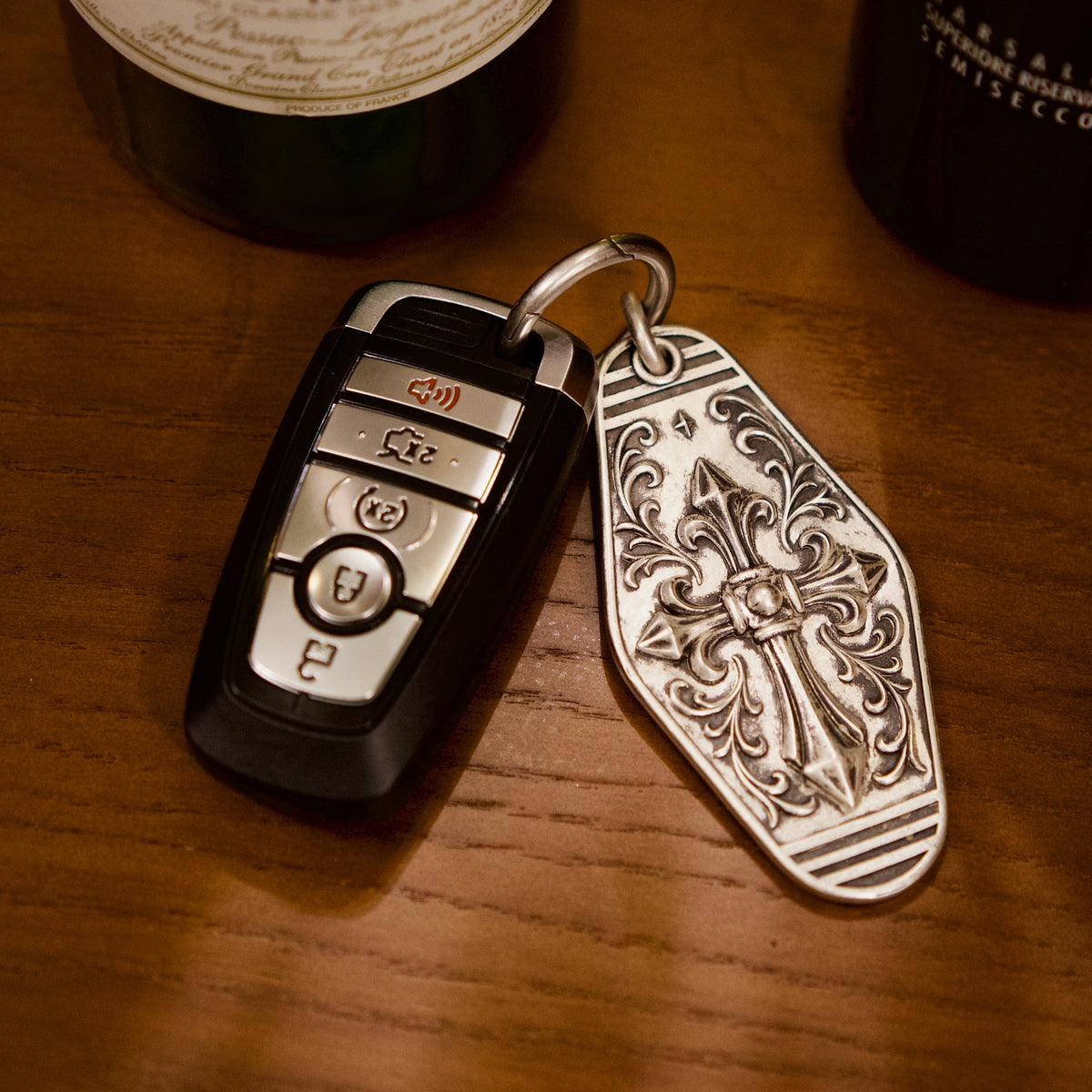 Personalized Cathedral Cross Silver Keychain, front view beside a car key