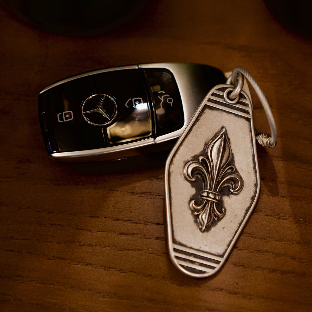 Royal Fleur Personalized Silver Keychain, front view beside a car key
