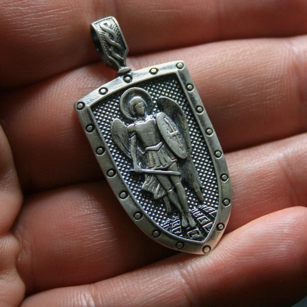 Saint Michael 925 Silver Shield Pendant, displayed on a dark surface