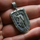 Saint Michael 925 Silver Shield Pendant, displayed on a dark surface