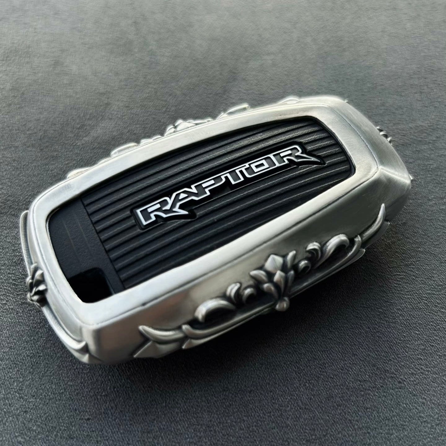 Sterling Silver Ford Bronco Raptor key case with floral scrollwork engraving and original RAPTOR badge preserved