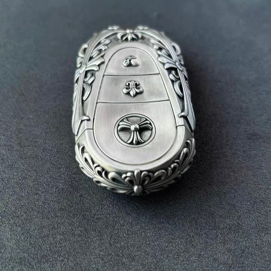 Hand holding precision-crafted Mercedes key case, demonstrating substantial weight